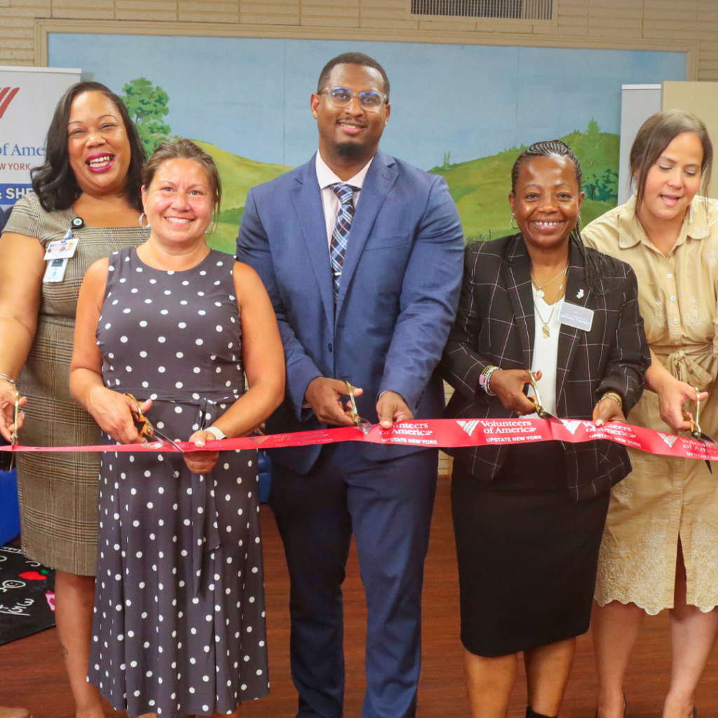 Dr. Junior Dillion cuts a ribbon with other officials for the opening of the Moving Forward Family Shelter