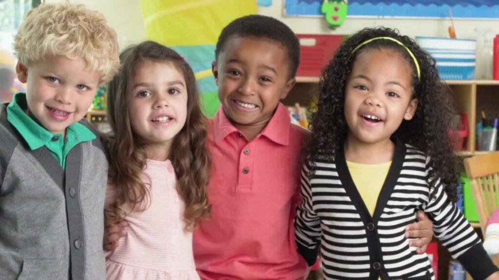 Four preschool age children gleefully smile for a camera.

Caring Gift of Education