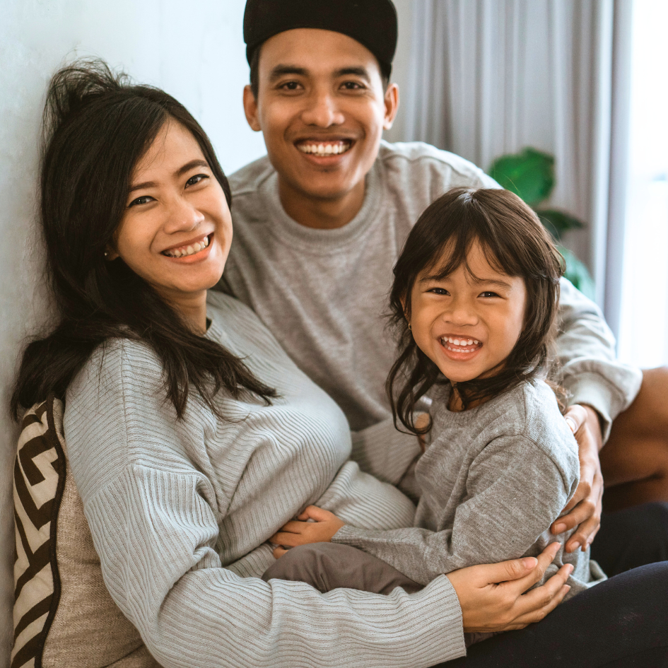 smiling family with mom, dad, and daughter