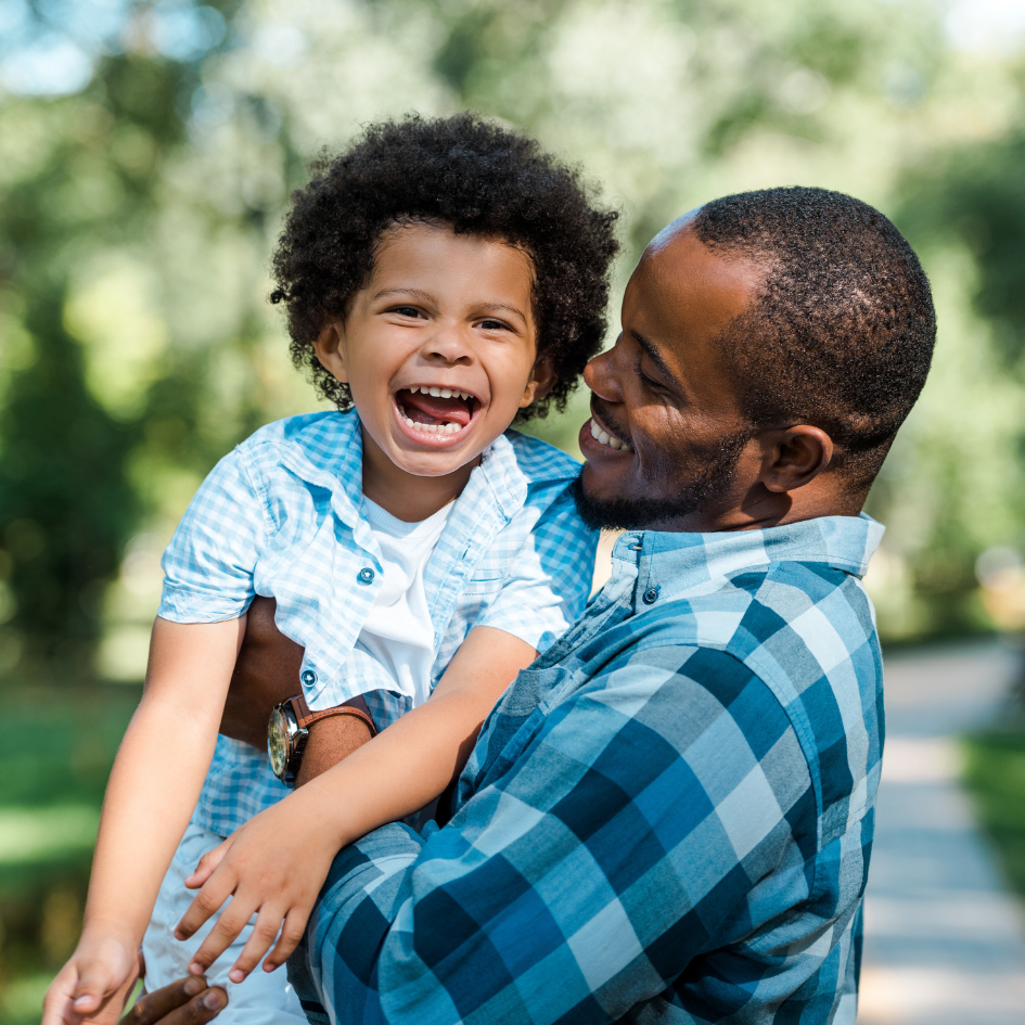 Father holding laughing son.